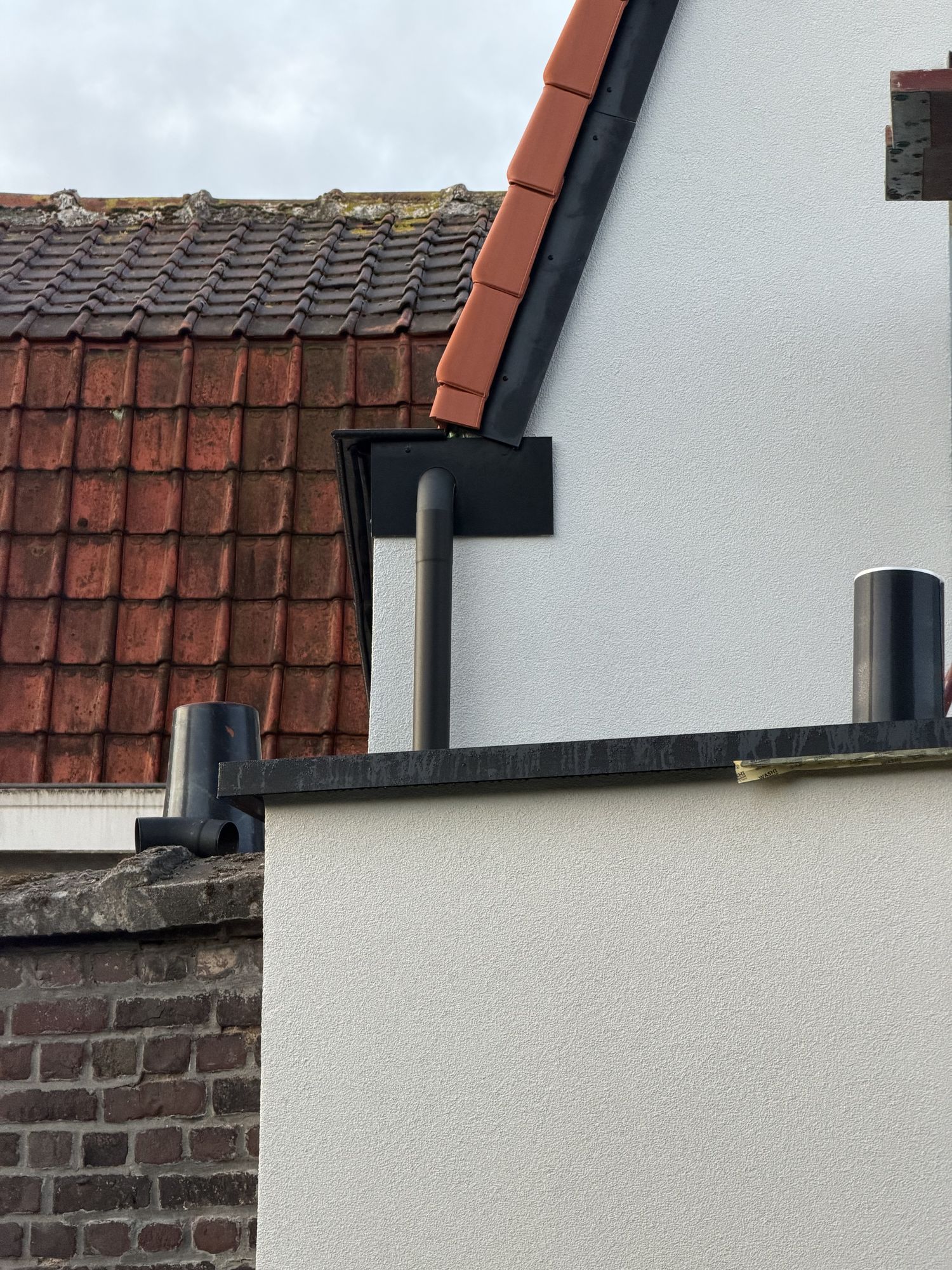 Detail in Oostakker van de aansluiting tussen het nieuwe dak, de gevelpleister en het aluminium afdekprofiel
