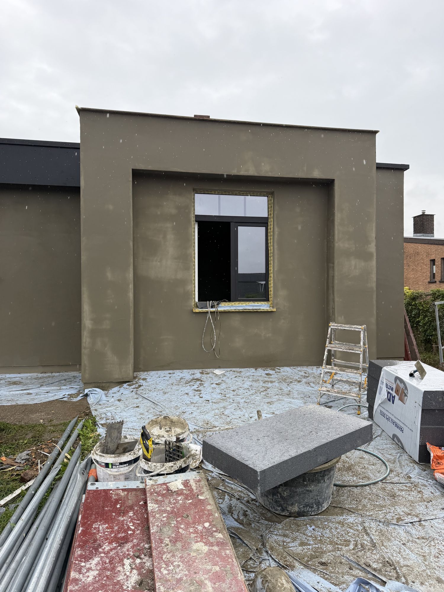 De basislaag rond een raamomlijsting met afwerkprofiel, klaar voor de crepi, aan de gevel in Pittem