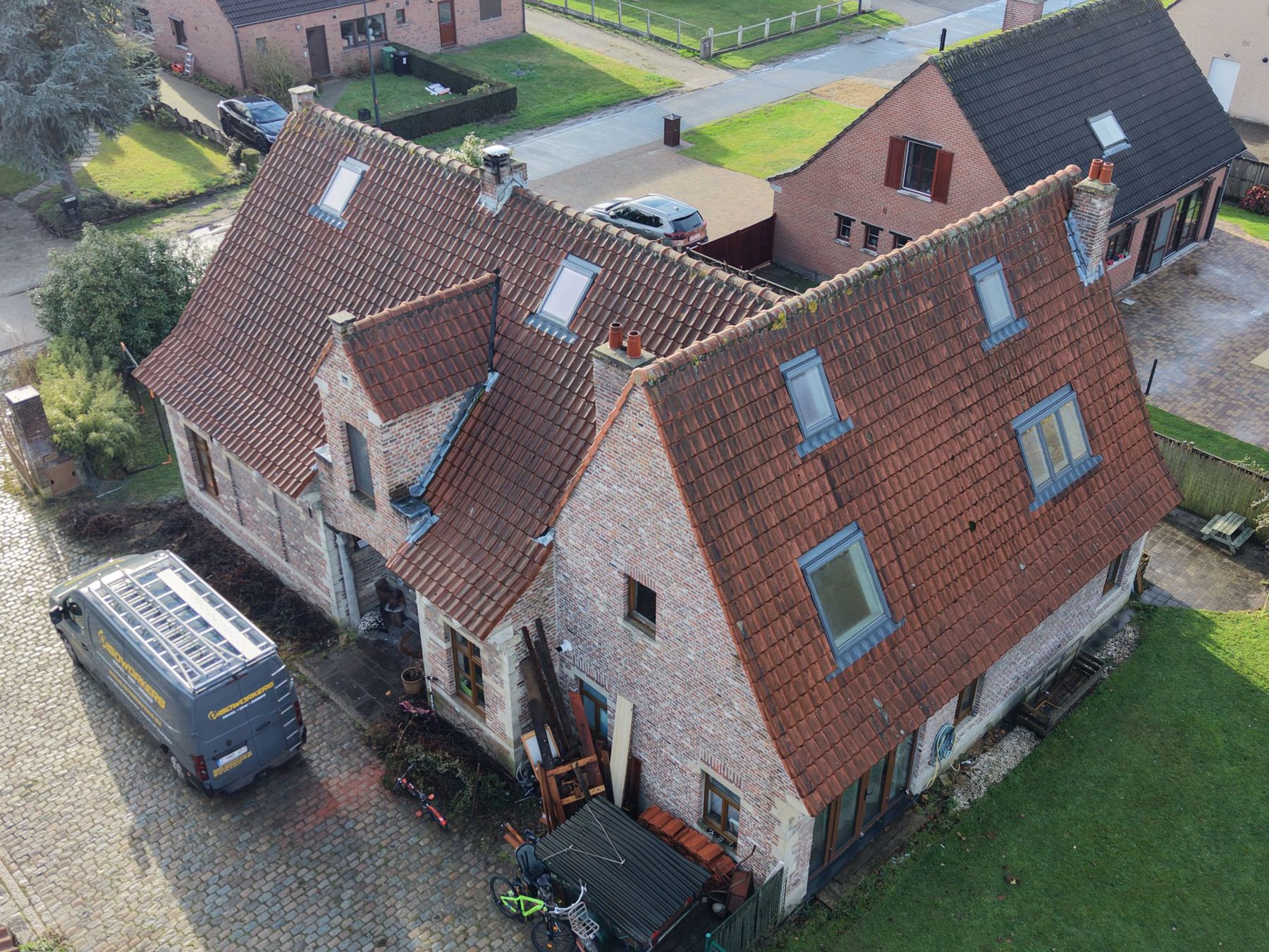 De woning in Oostakker vanuit de lucht, met de nieuwe dakvlakramen in het hoofddak en de aanbouw ernaast