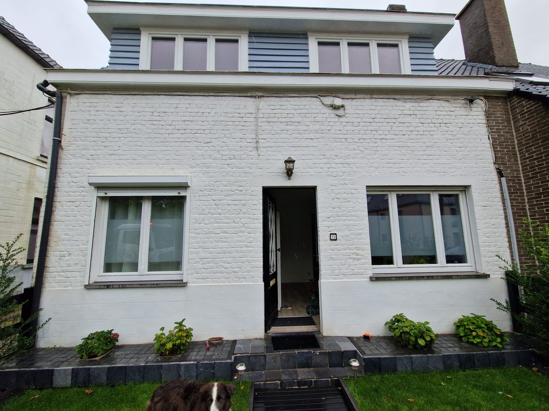 De wit geschilderde baksteengevel in Evergem voor de werken