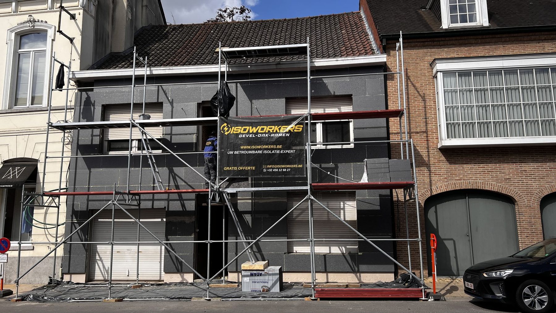 De stelling tegen de voorgevel in Oostrozebeke tijdens de gevelisolatie, tot tegen de gevel van de buur