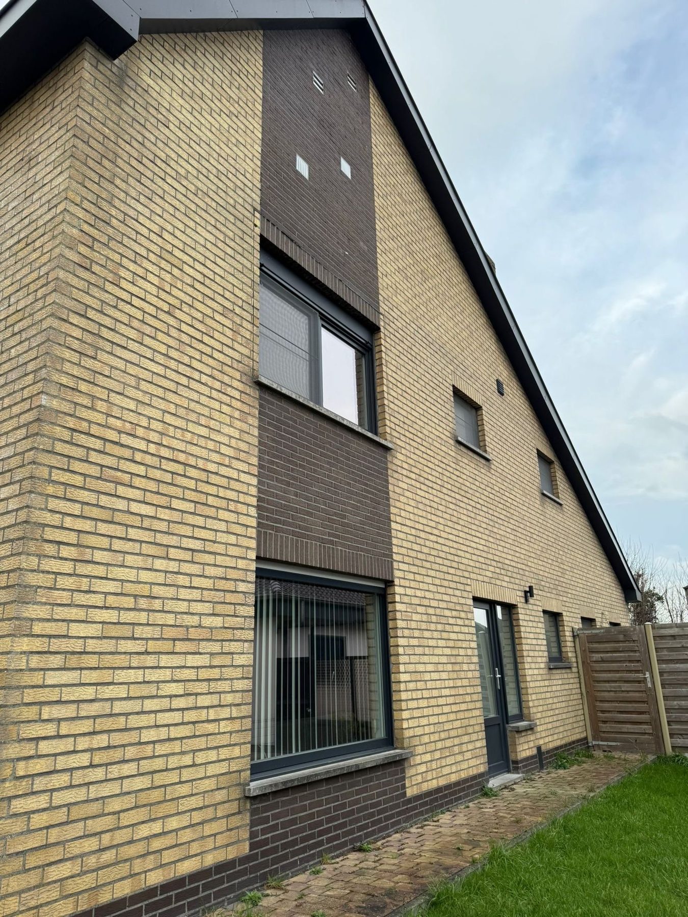 De gevel in Oudenburg voor de werken, in gele baksteen met een donkere accentkolom