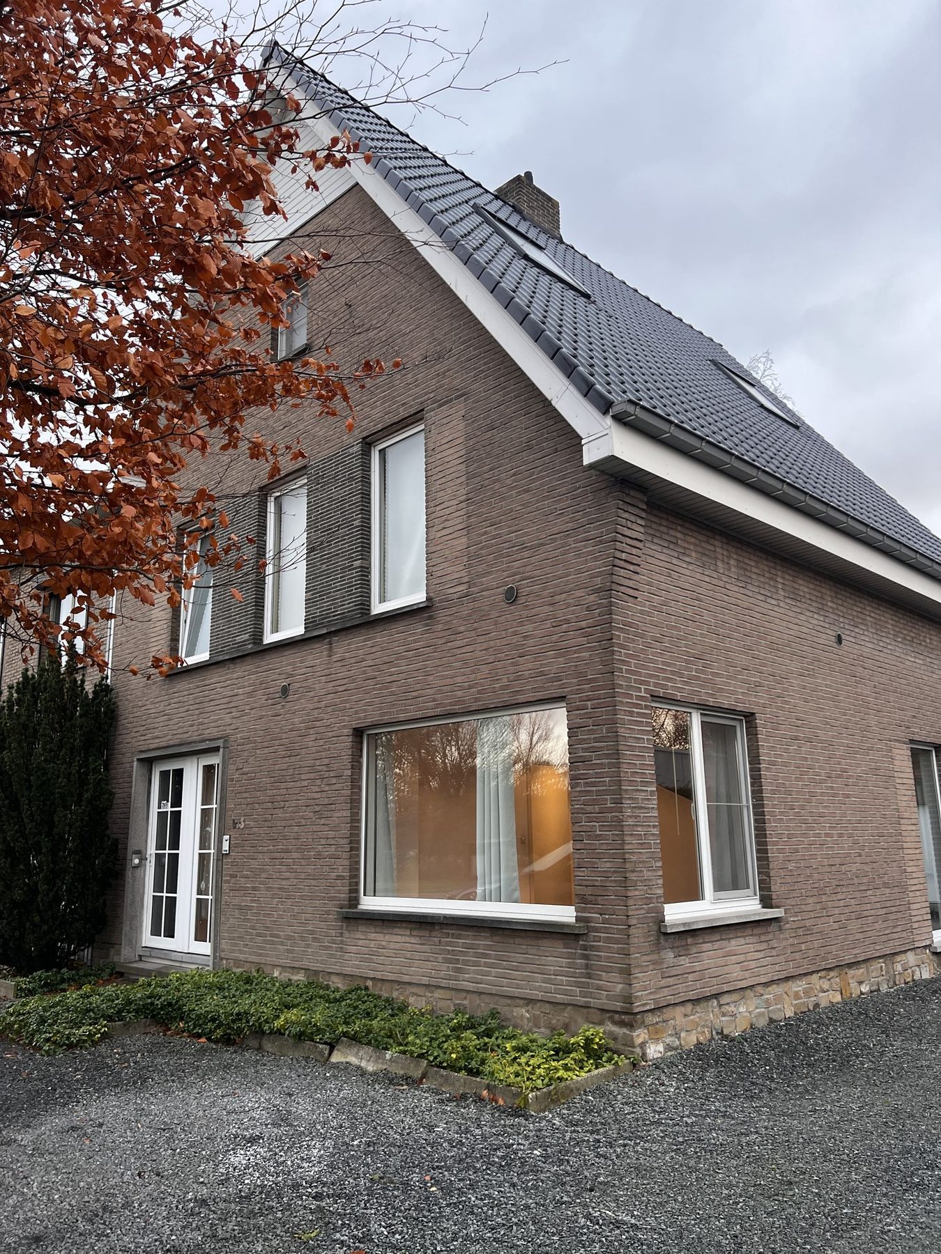 De halfopen woning in Merelbeke voor de werken, met de onbehandelde baksteengevel