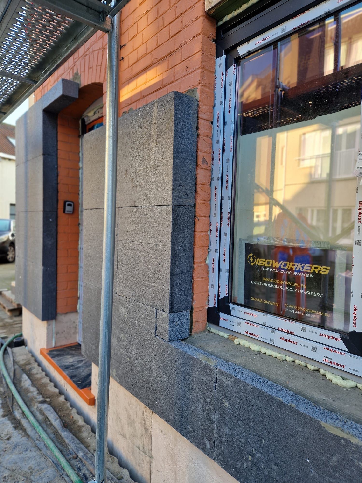 Nieuw raam met ISOWORKERS-sticker tijdens de plaatsing