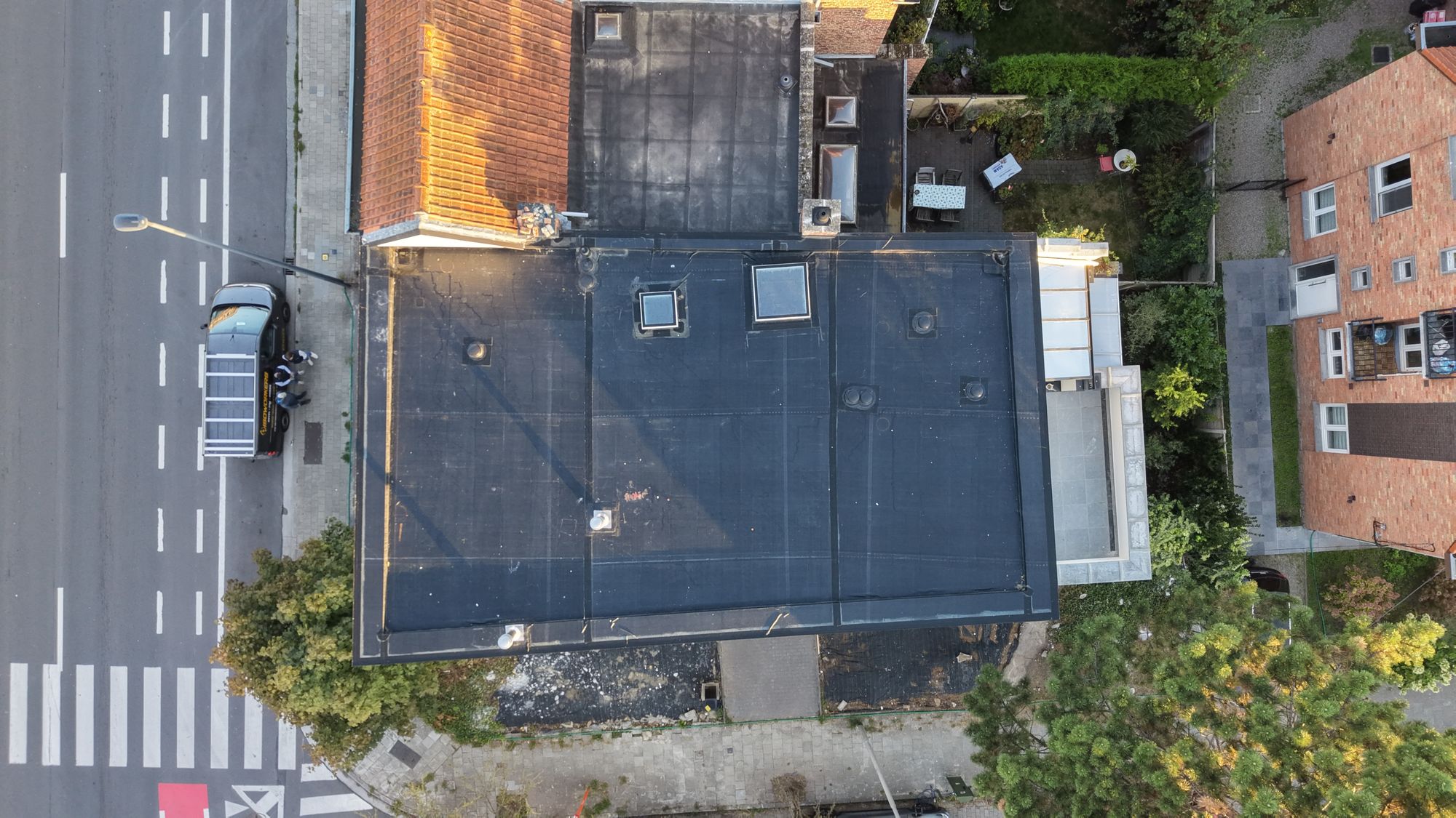 Bovenaanzicht van het nieuwe EPDM-dak in Gent met dakramen en aluminium dakrand
