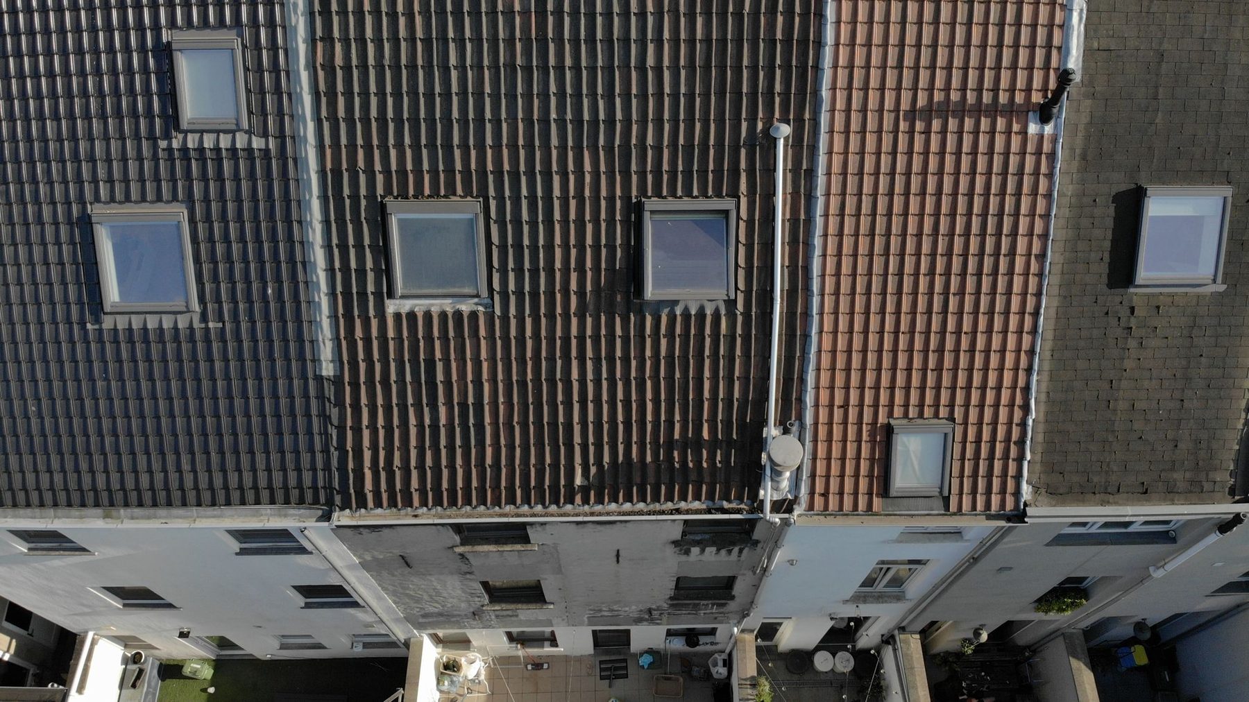 Het Gentse dak voor de renovatie, met de oude dakbedekking en de oude dakvensters