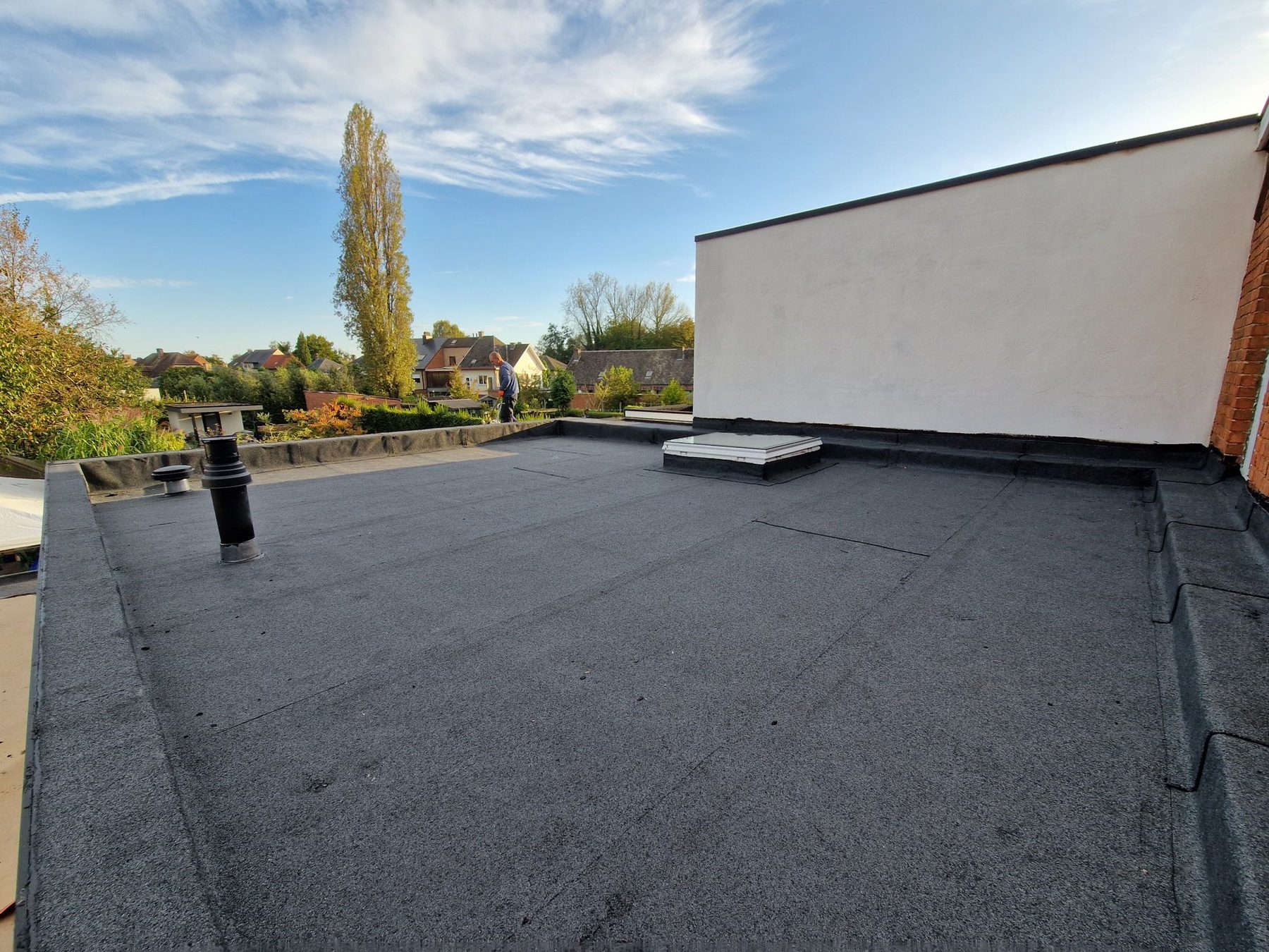 Het nieuwe platte dak in Hamme afgewerkt met roofing in twee lagen, met de lichtkoepel al geplaatst