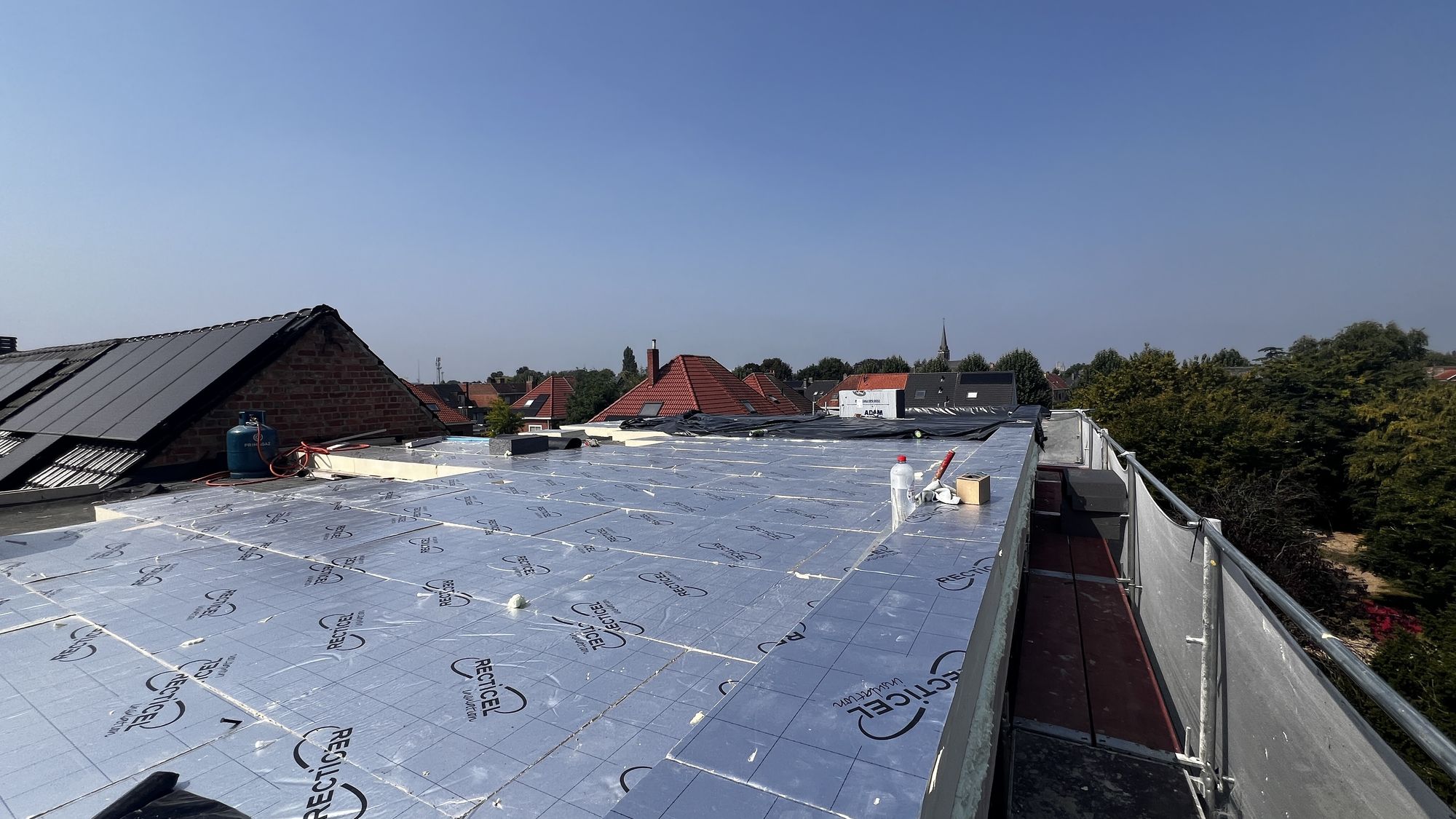 Het platte dak in Gent tijdens de werken, met de nieuwe PIR-isolatieplaten voor de roofing erop komt