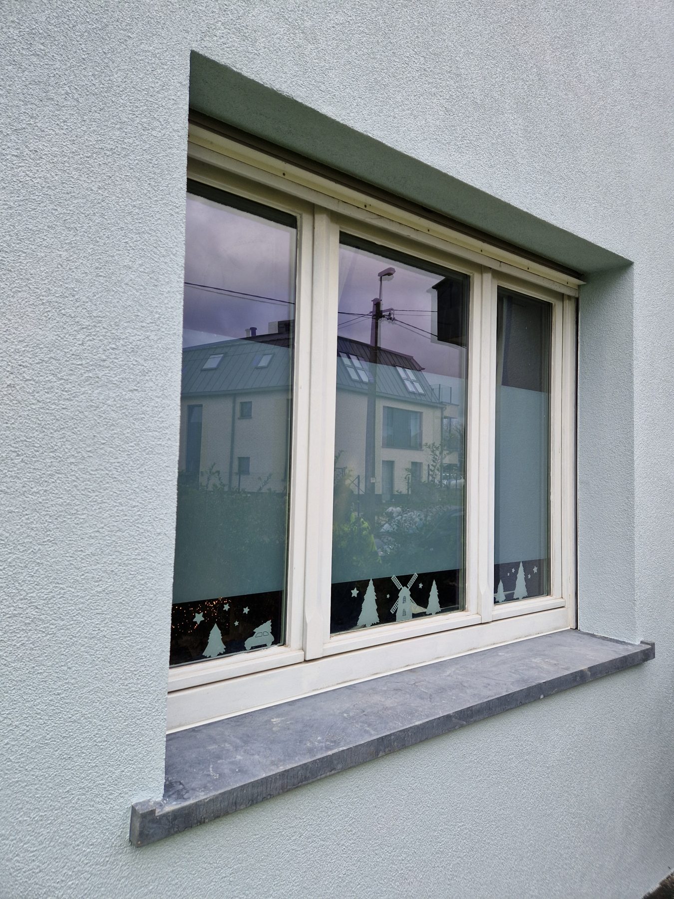 Een raam in Evergem met geisoleerde dagkant, crepi en een raamtablet in blauwe steen
