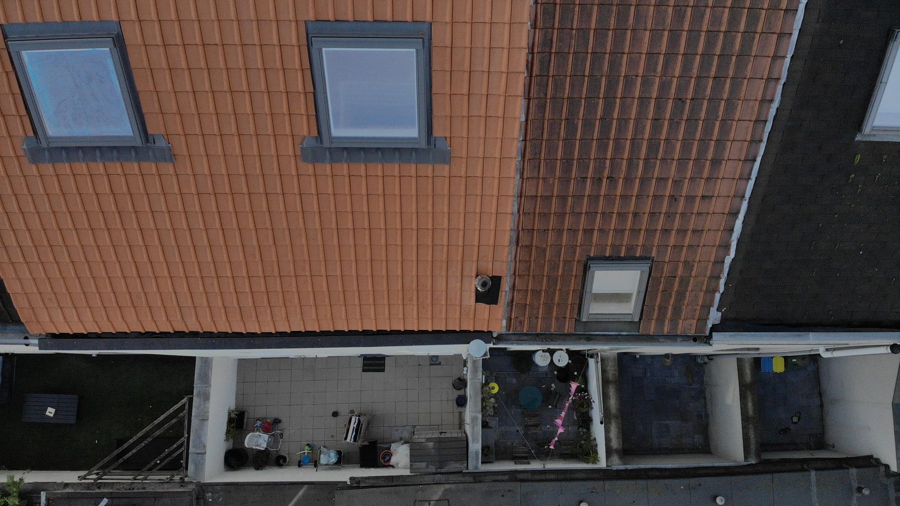 Het nieuwe sarkingdak in Gent van bovenaf, met de nieuwe pannen en twee vernieuwde dakvensters