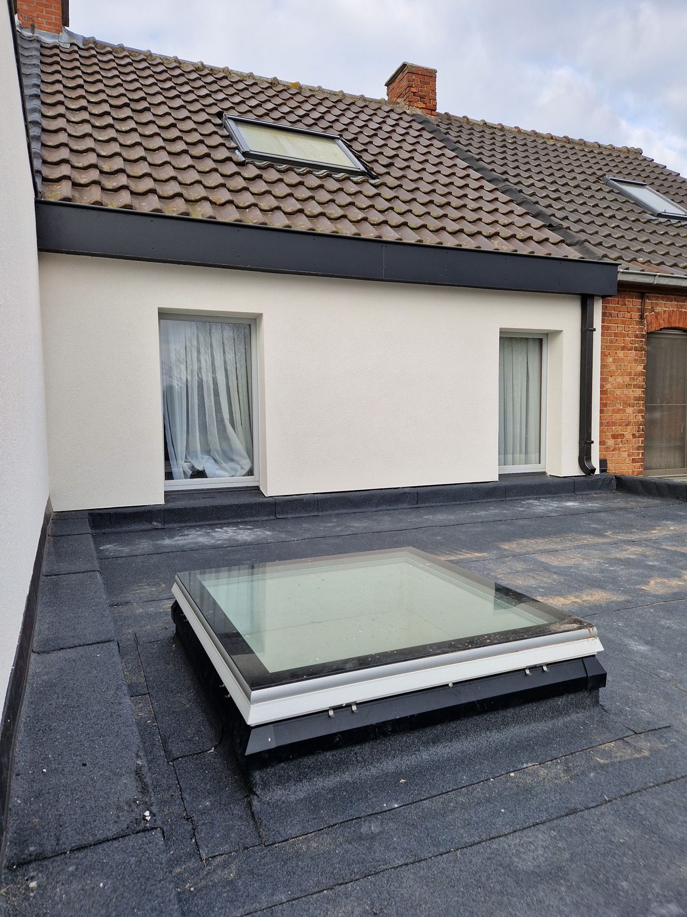 De vlakke glaskoepel Skylux iWindow2 in het nieuwe platte dak in Hamme