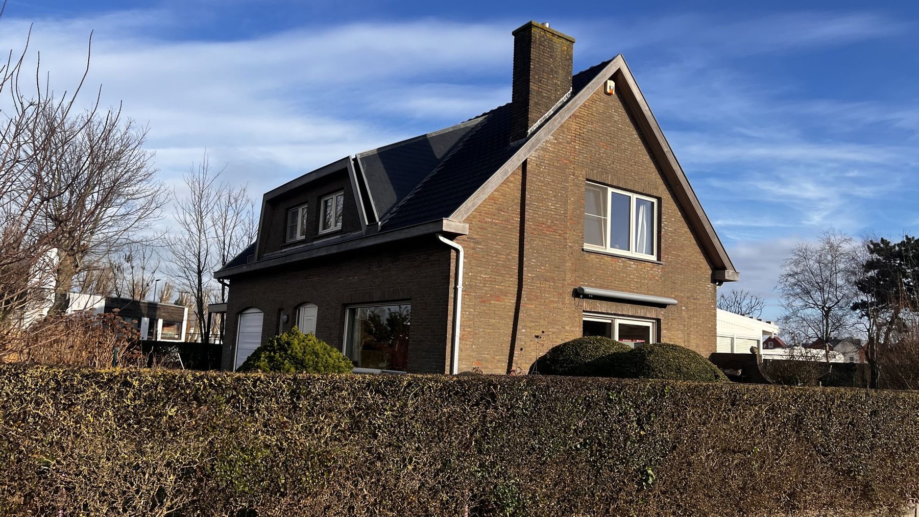 De woning in Oostende voor de werken, met de donkere baksteengevel en een zichtbare scheur in de zijgevel