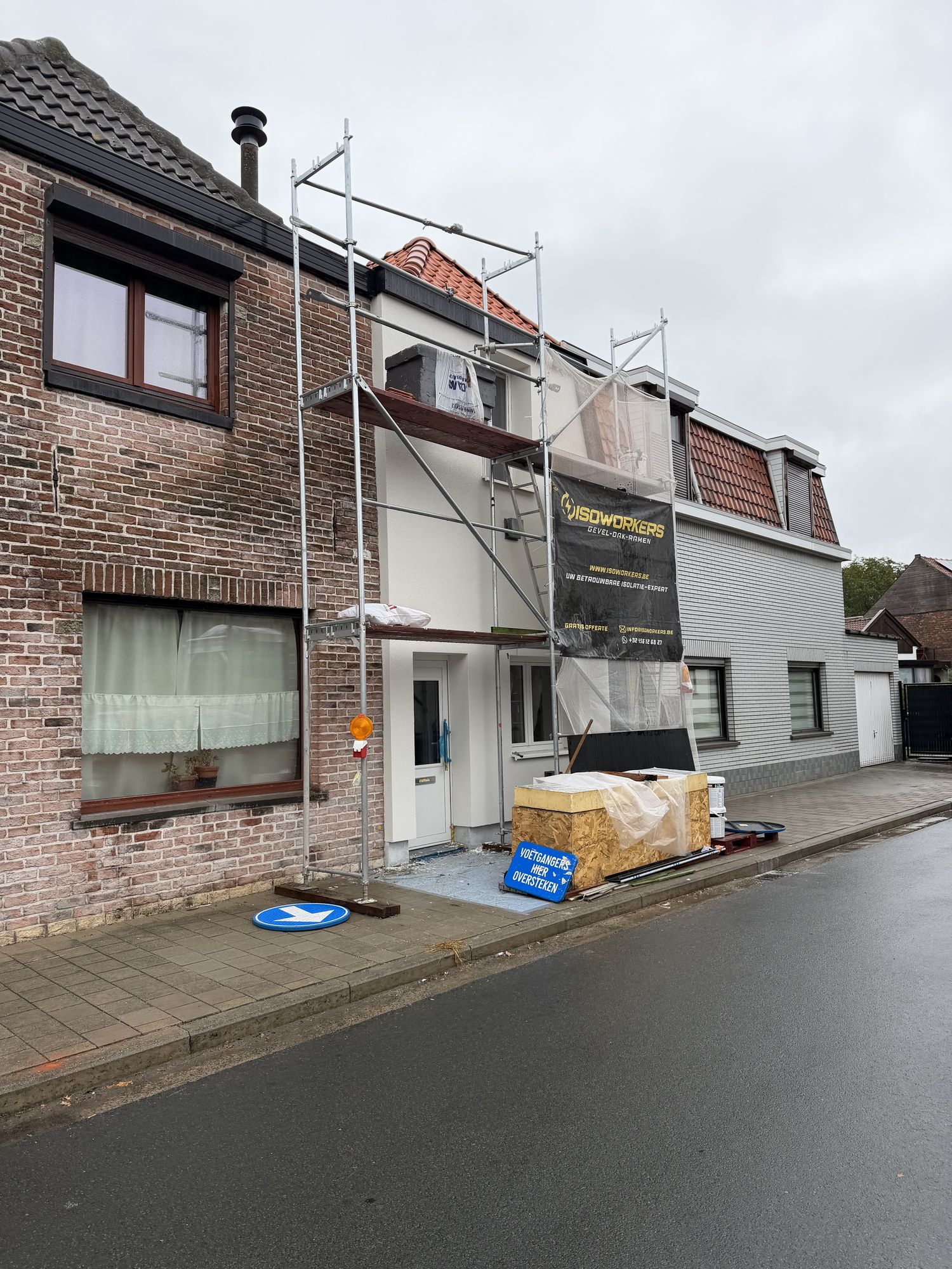 De stelling met ISOWORKERS-banner tegen de voorgevel van de rijwoning in Oostakker