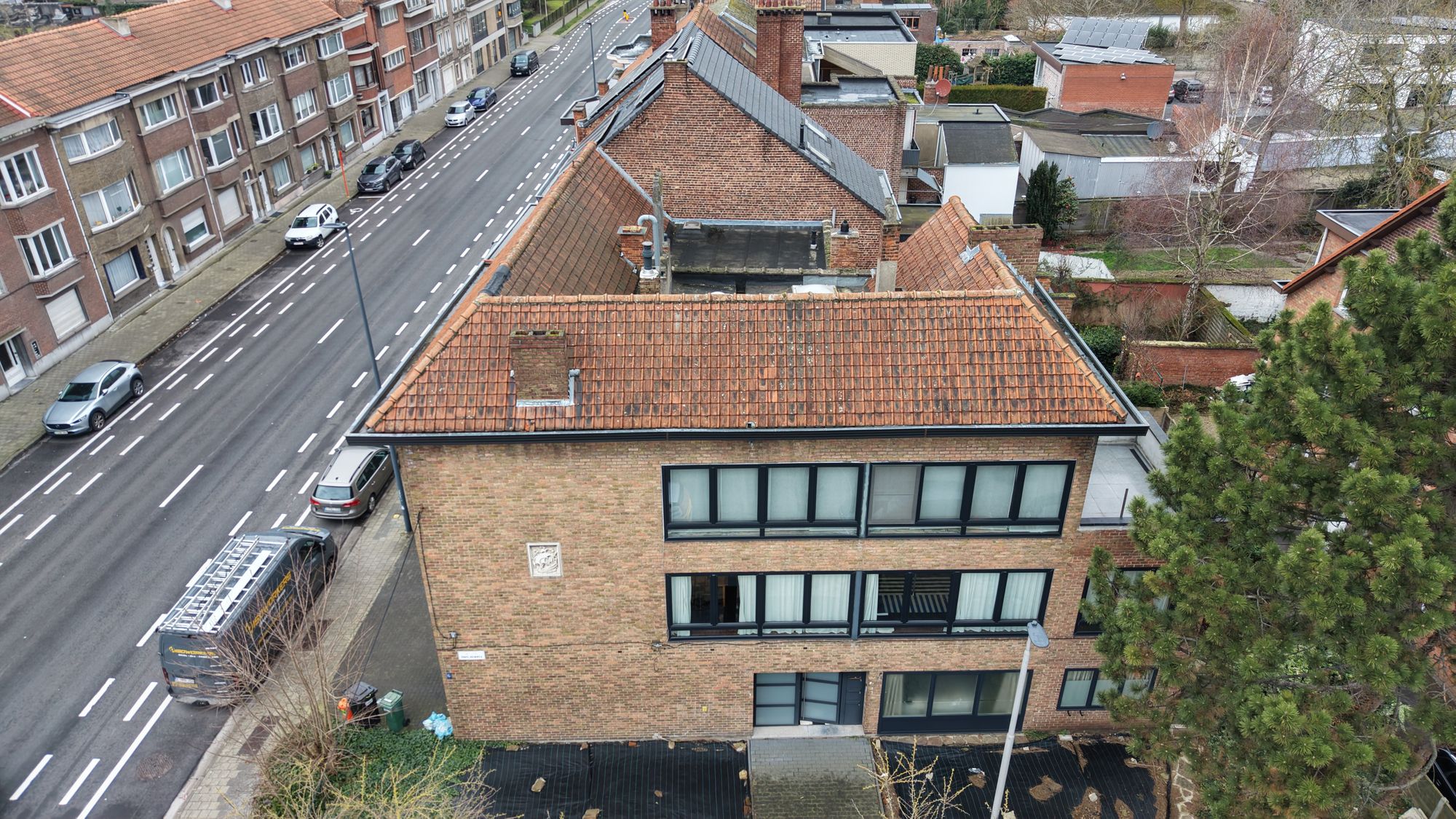 Luchtfoto van de voorgevel van het hoekgebouw in Gent met het oude schilddak